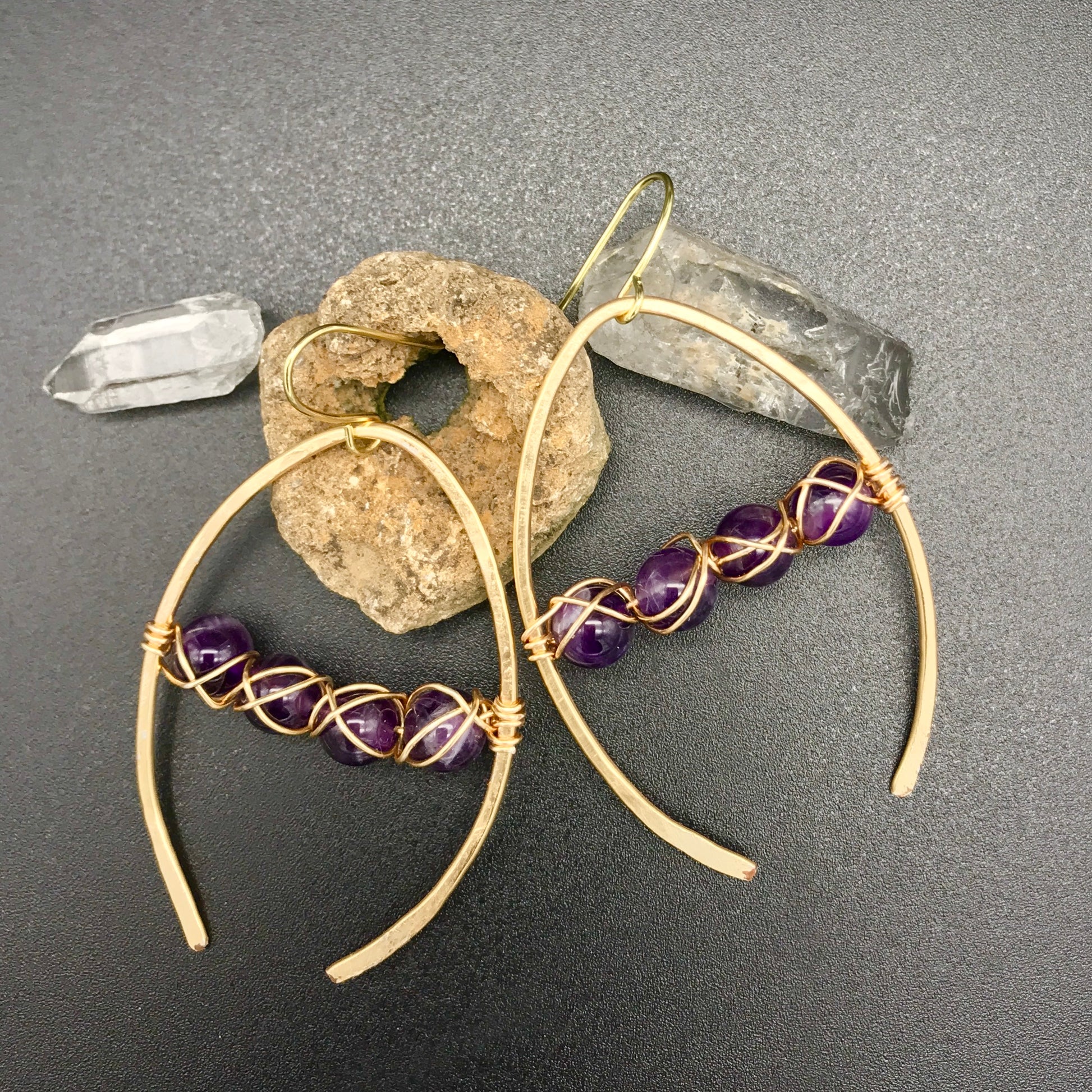 Wishbone shaped earrings in gold with woven amethyst beads. Rocking Glass Studio